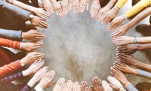 diverse group of people with hands making a circle